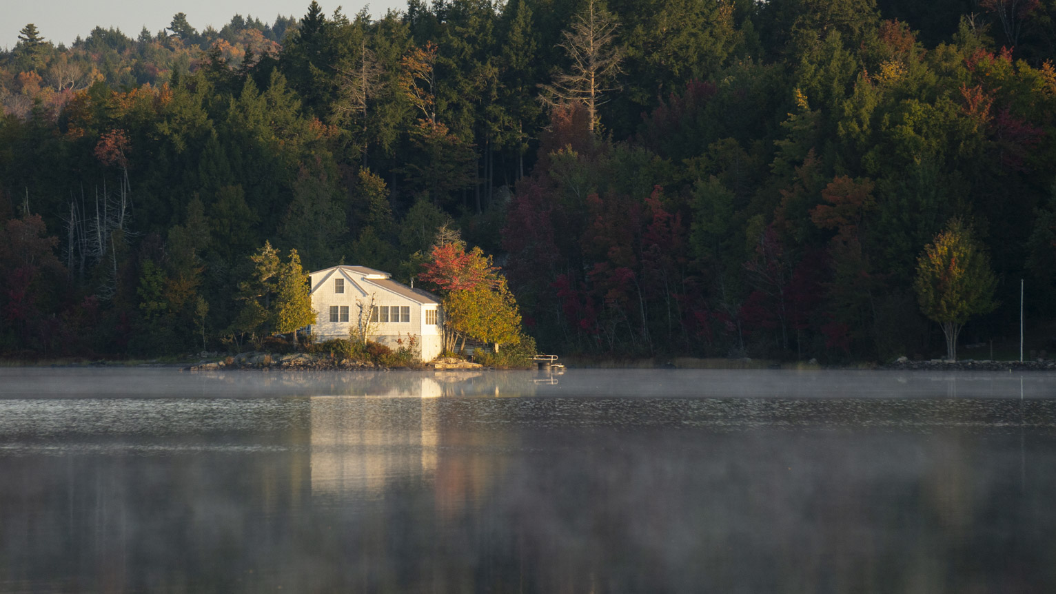 A white house on an island in a lake